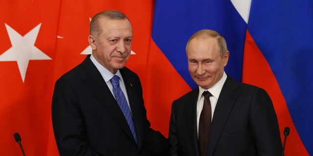 Russian President Vladimir Putin and Turkish President Recep Tayyip Erdogan shake hands during their talks at the Kremlin on March 5, 2020, in Moscow. 