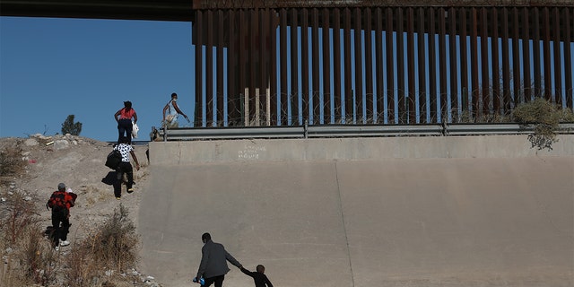 Haitian families crossing the Rio Bravo illegally to surrender at the border of Mexico's Ciudad Juarez with El Paso, Texas, in December 2021.