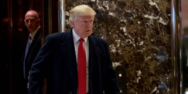 President-elect Donald Trump comes to the lobby to speak to members of the media at Trump Tower in New York, Dec. 6, 2016.