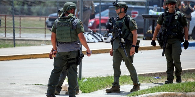 Law enforcement personnel stand outside Robb Elementary School following a shooting, Tuesday, May 24, 2022, in Uvalde, Texas.