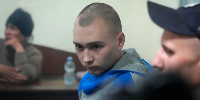 Russian army Sgt. Vadim Shishimarin, 21, is seen behind a glass during a court hearing in Kyiv, Ukraine, on Wednesday, May 18. He has been sentenced to life in prison for the killing of an unarmed civilian. 