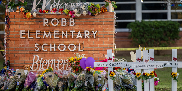 A memorial is seen surrounding the Robb Elementary School sign following the mass shooting at Robb Elementary School on May 26, 2022, in Uvalde, Texas. 