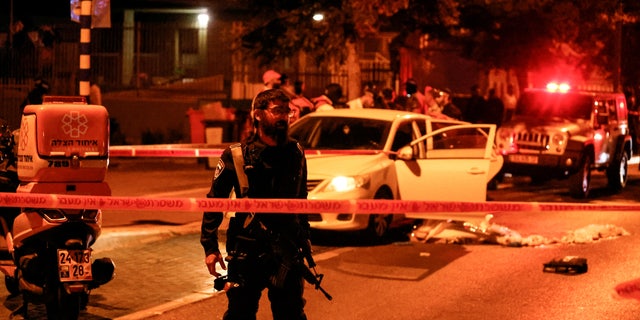 An Israeli police officer works at the scene following an incident in Elad in central Israel, May 5, 2022. 