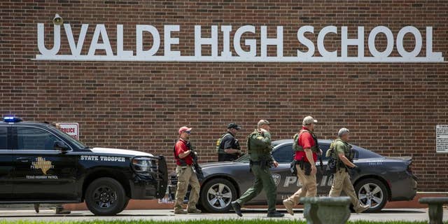 Law enforcement personnel walk outside Uvalde High School after shooting a was reported earlier in the day at Robb Elementary School, Tuesday, May 24, 2022, in Uvalde, Texas.