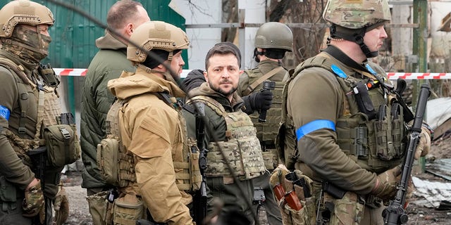 Ukrainian President Volodymyr Zelenskyy examines the site of a recent battle in Bucha, close to Kyiv, Ukraine, Monday, Apr. 4, 2022. Russia is facing a fresh wave of condemnation after evidence emerged of what appeared to be deliberate killings of civilians in Ukraine. 