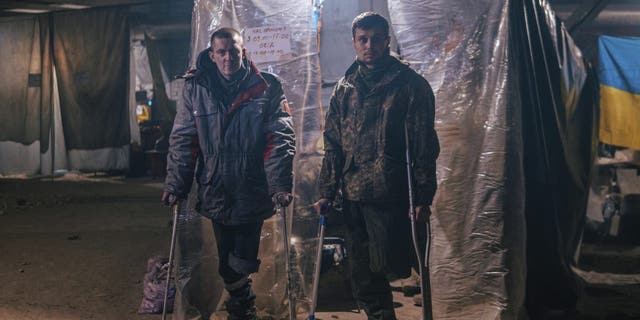 In this photo provided by Azov Special Forces Regiment of the Ukrainian National Guard Press Office, Azov Special Forces Regiment's servicemen, injured during fighting against Russian forces, pose for a photographer inside the Azovstal steel plant in Mariupol, Ukraine, Tuesday, May 10, 2022. 