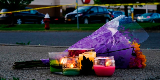 Flowers and candles lay outside the scene of the Tops shooting in Buffalo, N.Y., Sunday, May 15, 2022. 