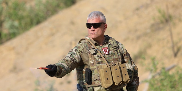 American former army member, Matthew Parker, holds a smoke grenade during a training session for Belarusian volunteers at a shooting range near Warsaw, Poland, on Friday, May 20, 2022. Belarusians are among those who have answered a call by Ukrainian President Volodymyr Zelenskyy for foreign fighters to go to Ukraine and join the International Legion for the Territorial Defense of Ukraine. 