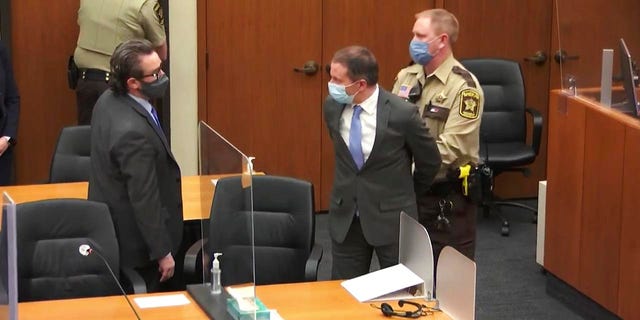 Former Minneapolis Police Officer Derek Chauvin, center, is taken into custody as his attorney, Eric Nelson, left, looks on after the verdicts were read at Chauvin's trial for the 2020 death of George Floyd, at the Hennepin County Courthouse in Minneapolis, April 20, 2021. 