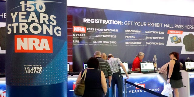 Convention attendees line up at the registration booth at the NRA Annual Meeting held at the George R. Brown Convention Center Thursday, May 26, 2022, in Houston. (AP Photo/Michael Wyke)