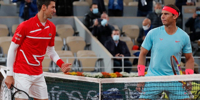 FILE - Serbia's Novak Djokovic, left, and Spain's Rafael Nadal look at each other as they pose for images prior to the final match of the French Open tennis tournament at Roland Garros stadium in Paris, France, Sunday, Oct. 11, 2020. 