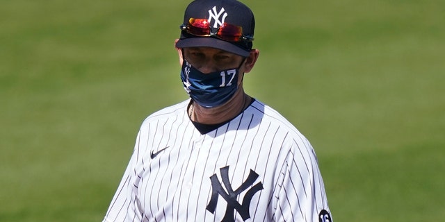 New York Yankees' Manager Aaron Boone stands on the field before a spring baseball game against the Toronto Blue Jays Sunday, Feb. 28, 2021, in Tampa, Fla.