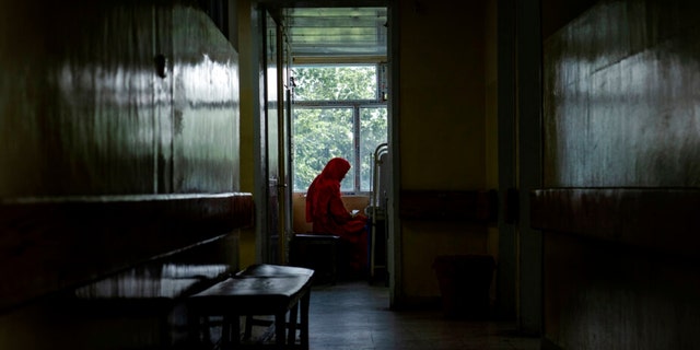 An Afghan mother sits by her child's bed at the malnutrition ward of the Indira Gandhi hospital in Kabul, Afghanistan, Sunday, May 22, 2022. 