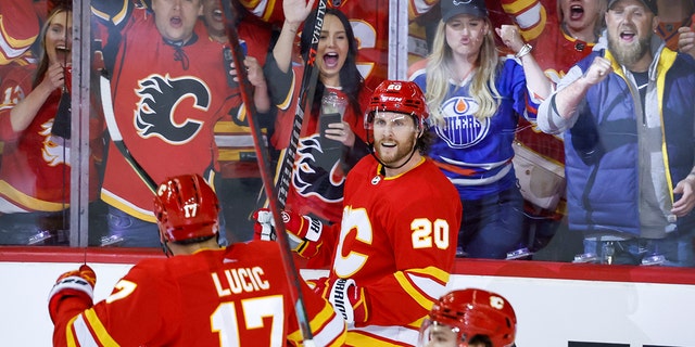 Calgary Flames forward Blake Coleman (20) celebrates his goal against the Edmonton Oilers with Milan Lucic (17) and Rasmus Andersson (4) during the second period of Game 1 of an NHL hockey second-round playoff series Wednesday, May 18, 2022, in Calgary, Alberta.