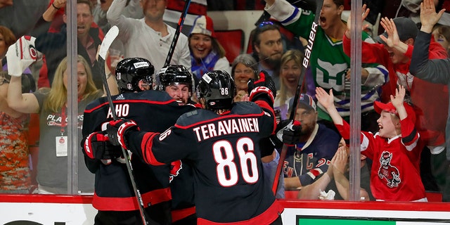 Carolina Hurricanes' Brendan Smith, center, celebrates his goal with teammates Sebastian Aho (20) and Teuvo Teravainen (86) during the second period of Game 2 of an NHL hockey Stanley Cup second-round playoff series in Raleigh, N.C., Friday, May 20, 2022.