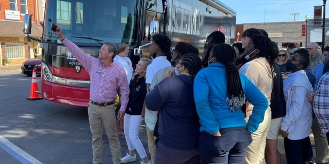 Gov. Brian Kemp takes a selfie with supporters on the campaign trail in Blakely, Georgia, on April 20, 2022.