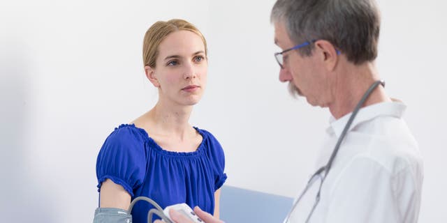 Taking a patients blood pressure.