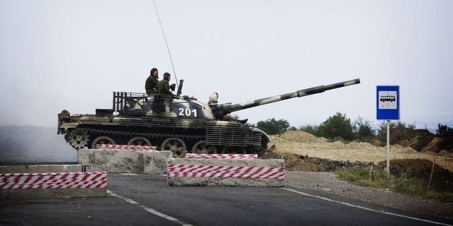 A Russian T62 tank crosses the empty highway linking Tbilisi and western Georgia on August 21, 2008 at a checkpoint manned by the Russian forces. Russia is not planning to "slam the door" on NATO, but the alliance must choose partnership with Moscow over support for Georgia, Foreign Minister Sergei Lavrov said today.  AFP PHOTO / MARCO LONGARI (Photo by Marco LONGARI / AFP) (Photo by MARCO LONGARI/AFP via Getty Images)