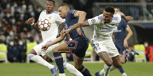 Kylian Mbappe, center, of Paris Saint-Germain, in action against Eder Militao, right, of Real Madrid, during a UEFA Champions League round of sixteen leg two match March 9, 2022, in Madrid, Spain. 