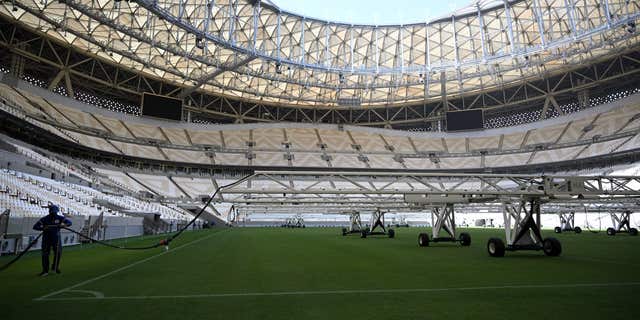 A man works on the pitch of the Lusail Stadium, the 80,000-capacity venue which will host the FIFA World Cup final in December, on the outskirts of Qatar's capital Doha on March 28, 2022.