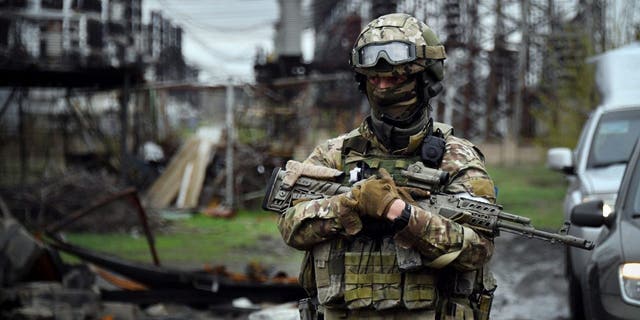 In this picture taken on April 13, 2022, a Russian soldier stands guard at the Luhansk power plant in the town of Shchastya. 