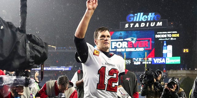 Tom Brady #12 of the Tampa Bay Buccaneers waves to the crowd as he runs off the field after defeating the New England Patriots in the game at Gillette Stadium on October 03, 2021 in Foxborough, Massachusetts.