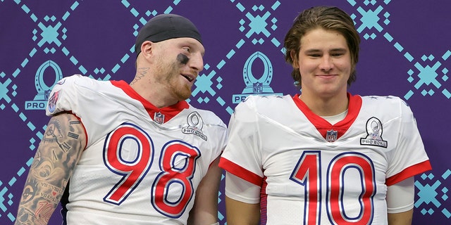 Defensive MVP Maxx Crosby #98 of the Las Vegas Raiders and AFC and offensive MVP Justin Herbert #10 of the Los Angeles Chargers and AFC talk as they wait to be interviewed after the AFC defeated the NFC 41-35 in the 2022 NFL Pro Bowl at Allegiant Stadium on Feb. 6, 2022 in Las Vegas, Nevada. 