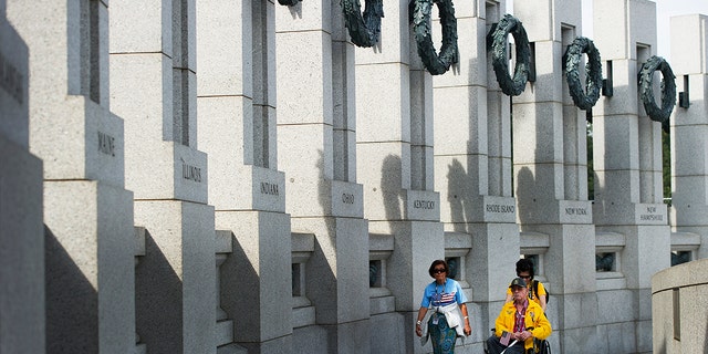 World War II veteran James Kauffman (R) is escorted by a member of Honor Flight while visiting the World War II Memorial in Washington, DC, October 3, 2013.