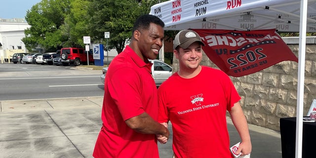 Republican Senate candidate Herschel Walker shakes hands with a supporter at a campaign event in Valdosta, Georgia, on May 21, 2022