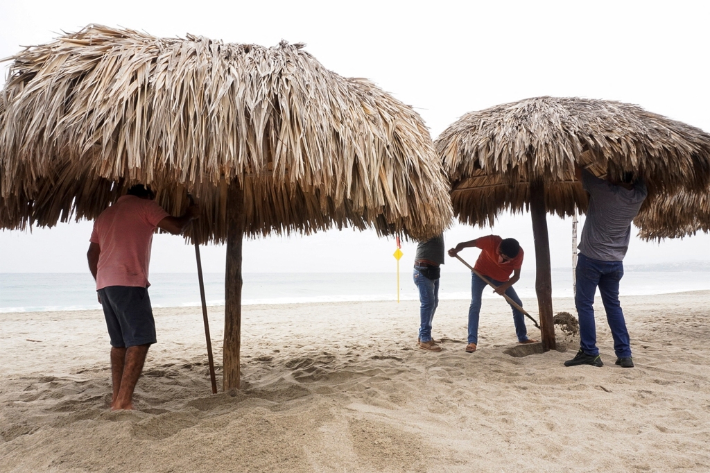 Men work on a beach as Hurricane Agatha barrels toward the southern coast of Mexico