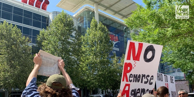 Protesters stand outside of the NRA Convention in Texas.