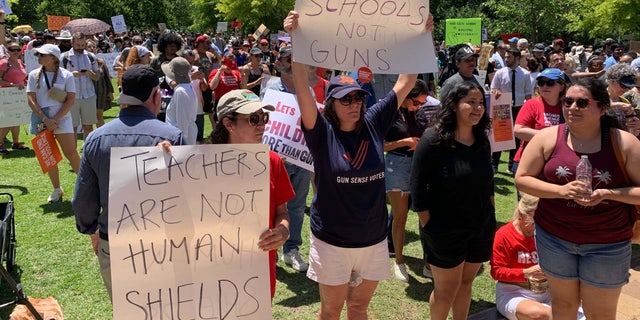 Protesters stand outside of the NRA Convention in Texas.