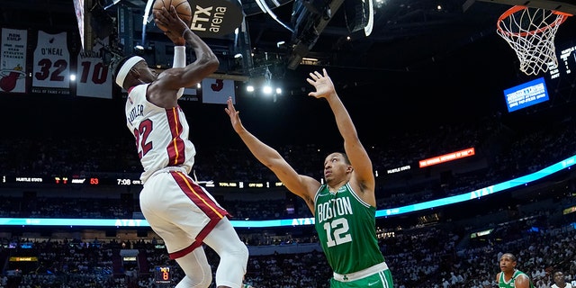 Miami Heat forward Jimmy Butler (22) aims to score as Boston Celtics forward Grant Williams (12) defends during the second half of Game 2 of the NBA basketball Eastern Conference finals playoff series, Thursday, May 19, 2022, in Miami.