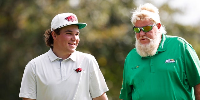 John Daly II, left walks off the fourth green with father John Daly during the second round of the PNC Championship golf tournament Sunday, Dec. 19, 2021, in Orlando, Fla.