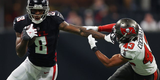 Kyle Pitts (8) of the Atlanta Falcons carries the ball after a reception as Ross Cockrell (43) of the Tampa Bay Buccaneers pursues at Mercedes-Benz Stadium Dec. 5, 2021, in Atlanta.