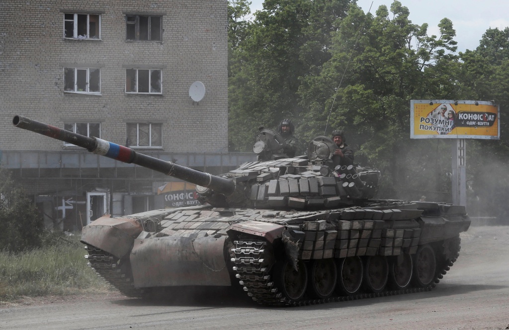 Service members of pro-Russian troops drive a tank along a street during Ukraine-Russia conflict in the town of Popasna, Ukraine, on May 26, 2022.