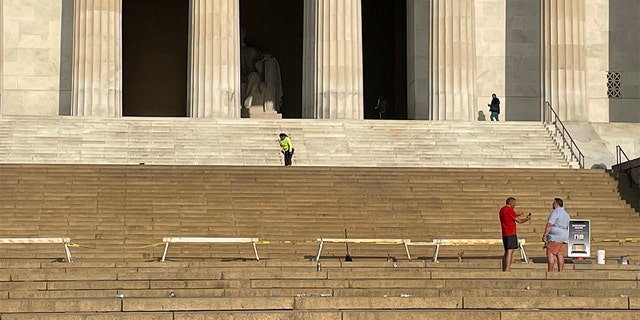 Workers clean the steps of the Lincoln Memorial in Washington Saturday, May 21, 2022, after broken bottles and spilled alcohol was found following a graduation celebration.