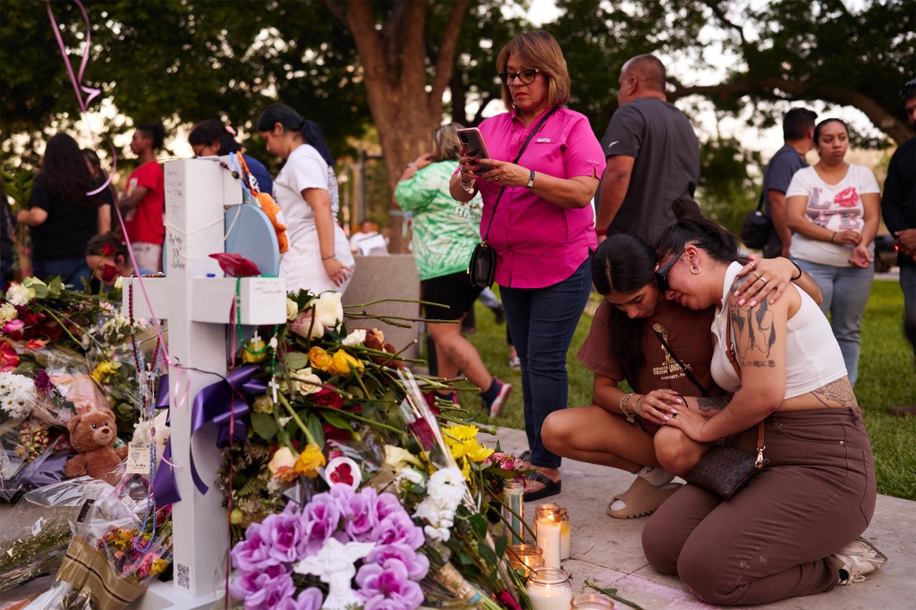 Two women comfort each other at a memorial at Uvalde’s town square.