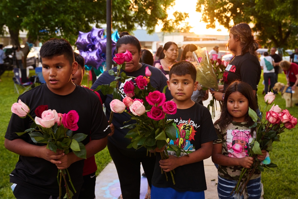 Children bring flowers to a memorial at Uvalde’s town square on May 27, 2022.