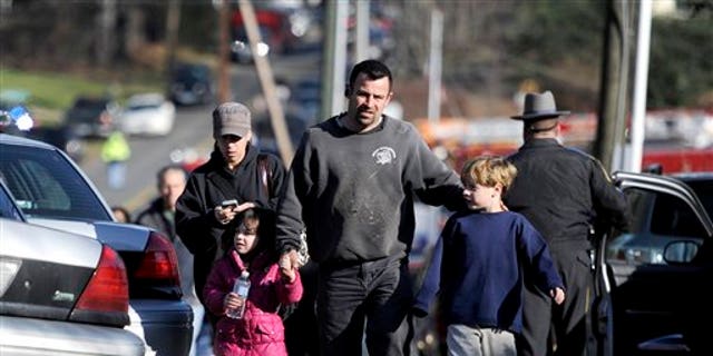 Parents leave a staging area after being reunited with their children following a shooting at the Sandy Hook Elementary School in Newtown, Connecticut.