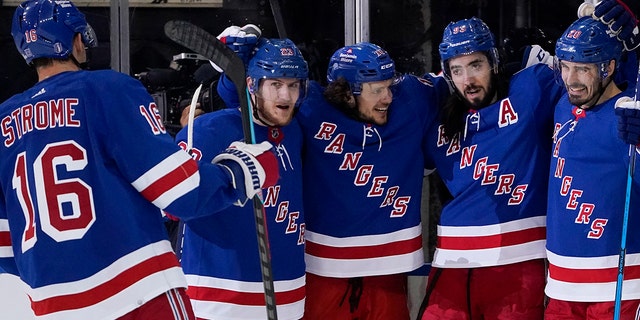 New York Rangers center Mika Zibanejad, second from right, celebrates after scoring on Carolina Hurricanes goaltender Antti Raanta during the first period of Game 6 of an NHL hockey Stanley Cup second-round playoff series, Saturday, May 28, 2022, in New York. (AP Photo/John Minchillo)