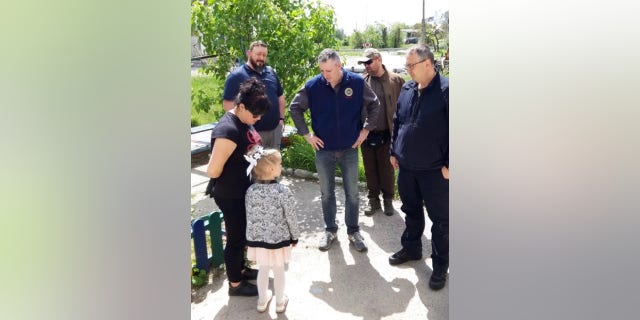 Rep. Brian Fitzpatrick speaks with kindergarten student and her mother after her school was damaged in war