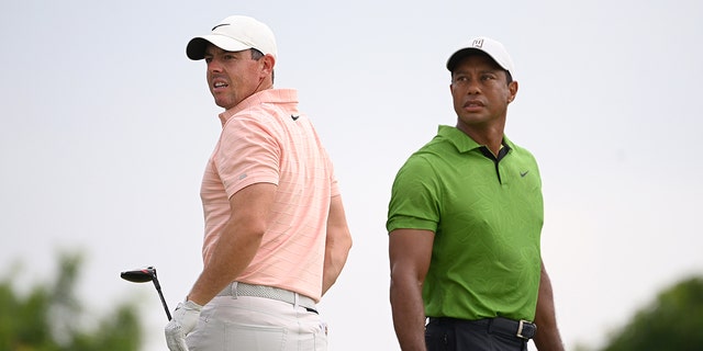 Rory McIlroy of Northern Ireland and Tiger Woods of the United States watch a tee shot on the 10th tee during the second round of the 2022 PGA Championship at Southern Hills Country Club on May 20, 2022 in Tulsa, Oklahoma.