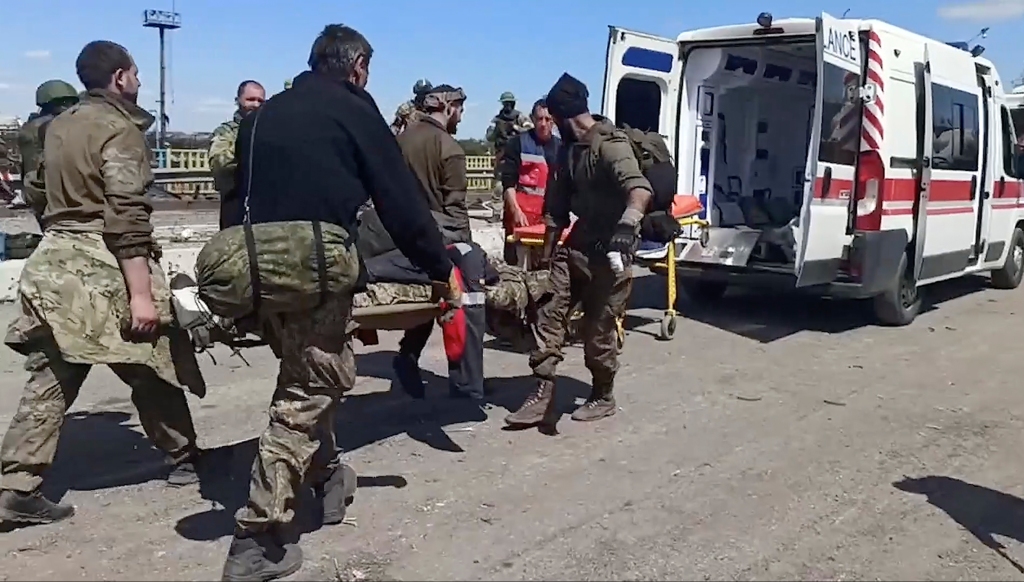 Ukrainian servicemen carry a wounded comrade after they left a steel plant in Mariupol, Ukraine on May 18, 2022.