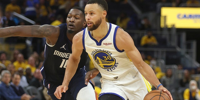 Golden State Warriors guard Stephen Curry (30) drives to the basket against Dallas Mavericks forward Dorian Finney-Smith during the second half of Game 2 of the NBA basketball playoffs Western Conference finals in San Francisco, Friday, May 20, 2022.