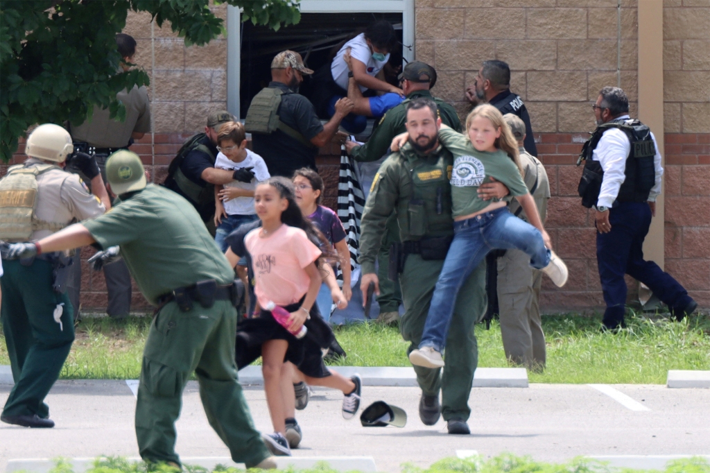 Police officers carry children out of a classroom window during the shooting.