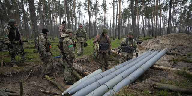 Ukrainian soldiers examine Russian multiple missiles abandoned by Russian troops, in the village of Berezivka, Ukraine, on April 21.