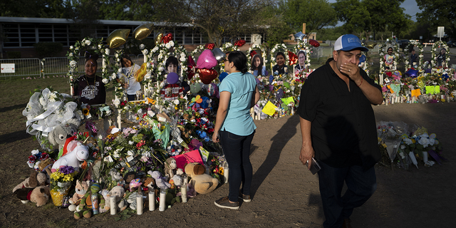 Rene Lucero and his wife, Alva, visit a memorial at Robb Elementary School in Uvalde, Texas, on Tuesday, May 31.