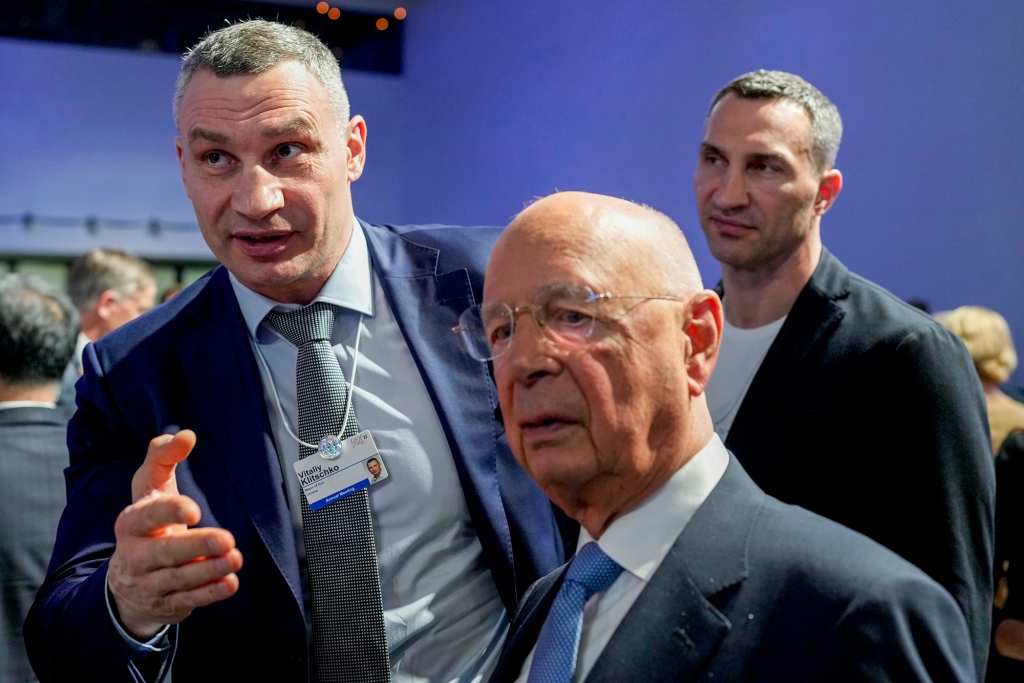 Kyiv Mayor Vitali Klitschko, left, and his brother Wladimir talk to Forum founder Klaus Schwab during the World Economic Forum in Davos, Switzerland, Monday.