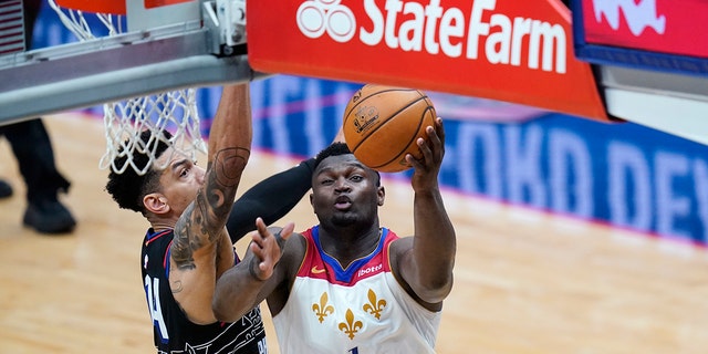 New Orleans Pelicans forward Zion Williamson (1) goes to the basket against Philadelphia 76ers forward Danny Green in the second half of an NBA basketball game in New Orleans, Friday, April 9, 2021.